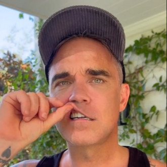 Robbie Williams shows off temporary set of teeth