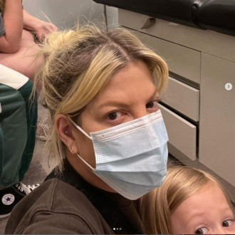 Bruised and wheelchair-bound Tori Spelling discharged from hospital after four-day treatment for mystery illness